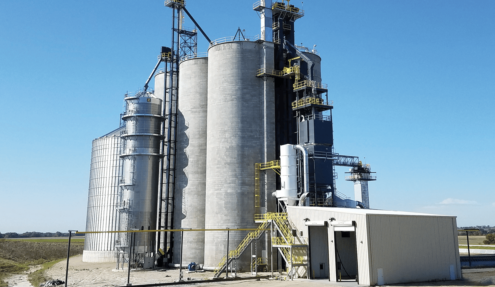 Industrial grain silos under clear sky