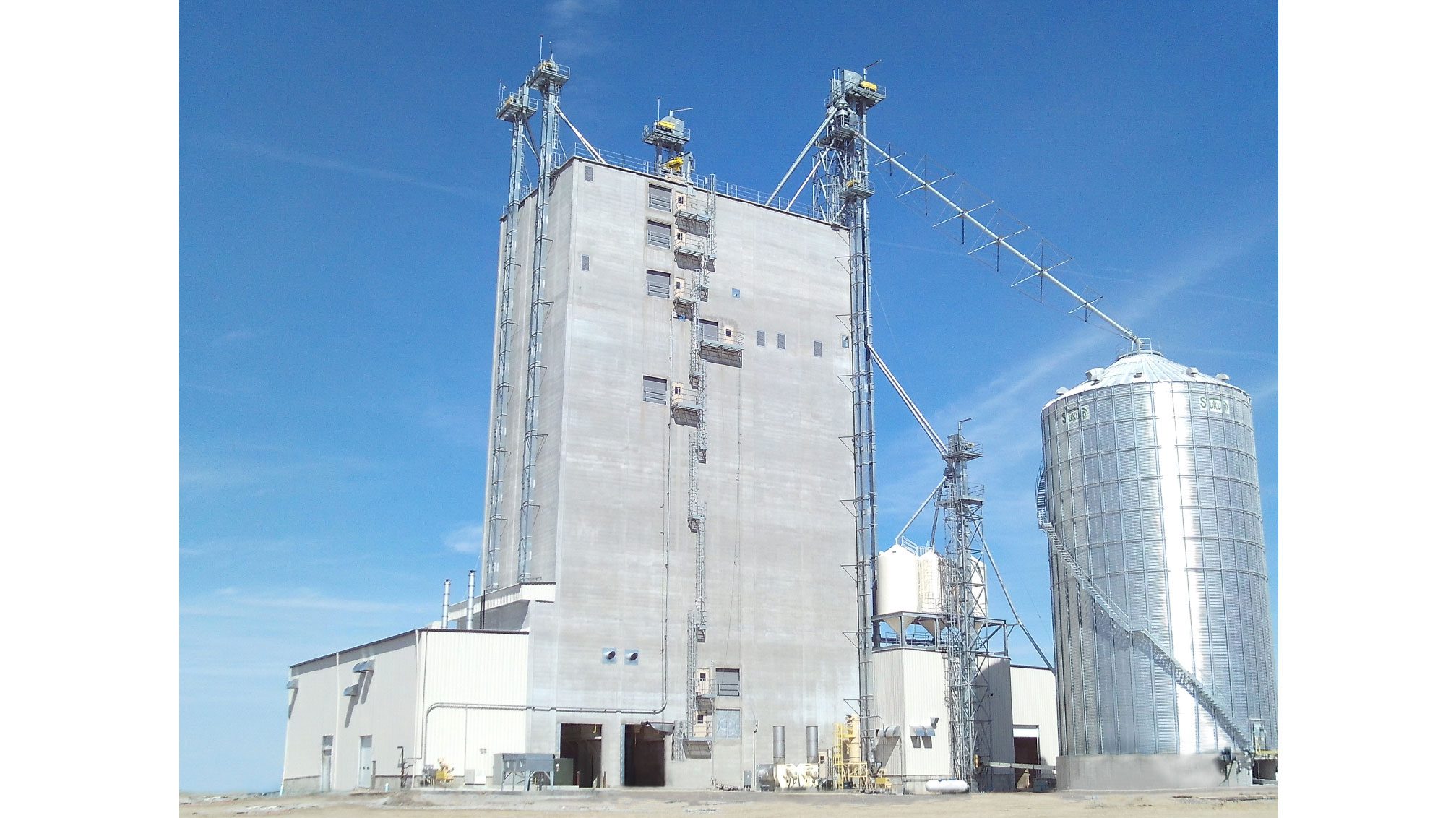 Grain elevator and silo against blue sky.